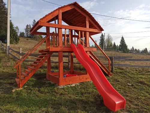 a wooden playset with a red slide at У Павла in Yablunytsya