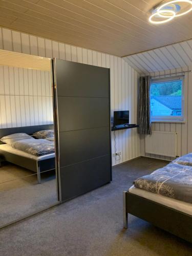 1 Schlafzimmer mit 2 Betten und einer Glasschiebetür in der Unterkunft Ferienwohnung am Rothenberg in Altenau