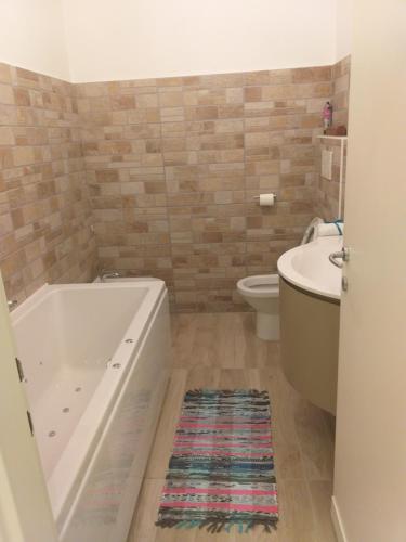 a bathroom with a tub and a toilet and a sink at Lux in Padova