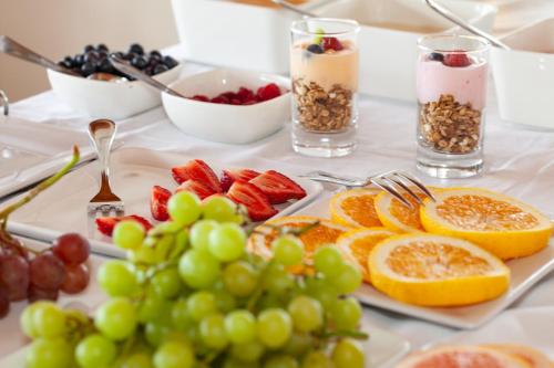 普利登堡湾长春花小屋宾馆的上面有水果和其他食物的桌子