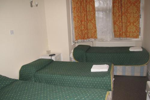 A bed or beds in a room at Chiswick Court Hotel - B&B 