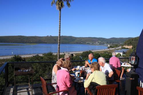 a group of people sitting at a table with a view at Lagoon Lodge in Knysna