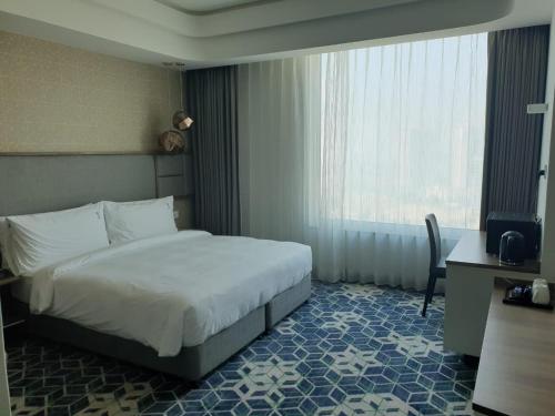 a hotel room with a bed and a window at Holiday Inn Gurugram Sector 90 by IHG in Gurgaon