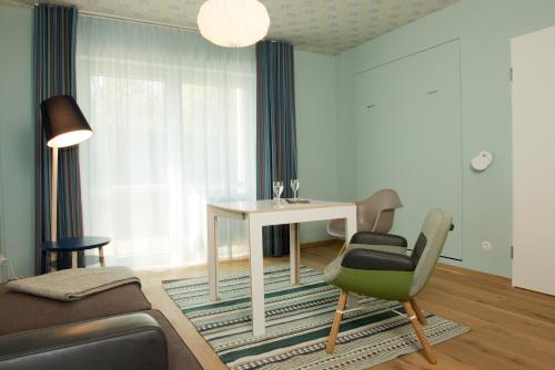 a living room with a table and a chair at Hotel Gude in Kassel