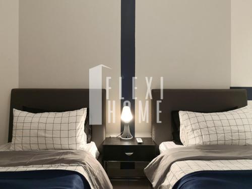 a bedroom with two beds and a lamp on a night stand at Spacious Big Room, Designed & Quiet Family Home, Eclipse in Cyberjaya by Flexihome-MY in Cyberjaya