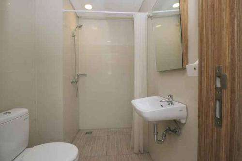 a bathroom with a toilet and a sink and a shower at Smarthomm Ancol Jakarta in Jakarta