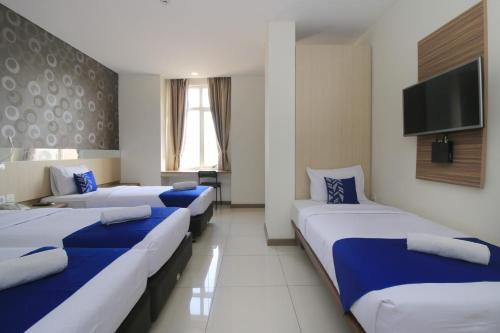 Säng eller sängar i ett rum på Smarthomm Ancol Jakarta