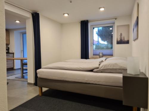 Schlafzimmer mit einem großen Bett und einem Fenster in der Unterkunft wohnung-nummer-1 in Pielenhofen