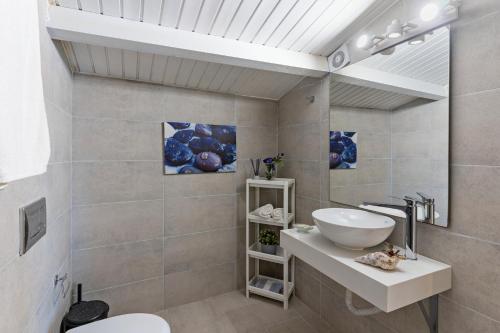 a bathroom with a sink and a toilet and a mirror at Castello Apartments in Panormos Rethymno