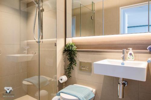 Un baño con lavabo, inodoro y espejo. en KOZYGURU DOCKLANDS LUXURY WATER VIEW APT 1 BED VDO915, en Melbourne