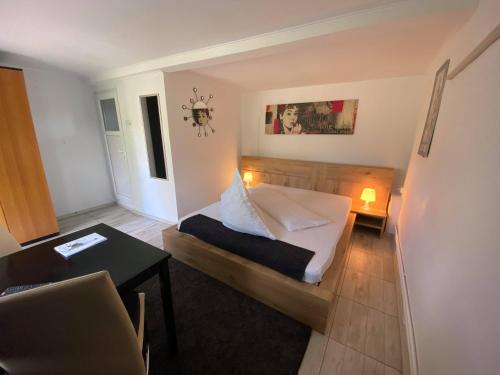 Dormitorio pequeño con cama y mesa en Pensiunea Bavaria Campina, en Campina