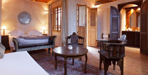 a living room with a bed and a table and chairs at Riad Chbanate in Essaouira