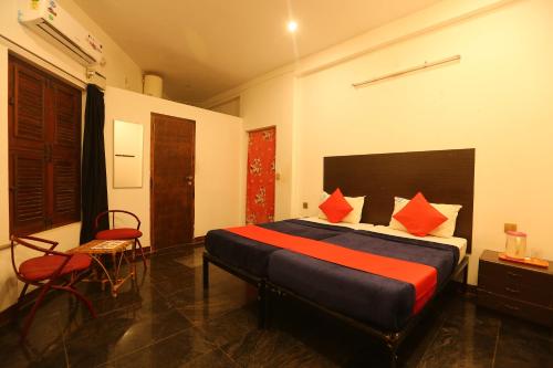 a bedroom with a bed and a chair in it at Le Apex Guest House in Auroville