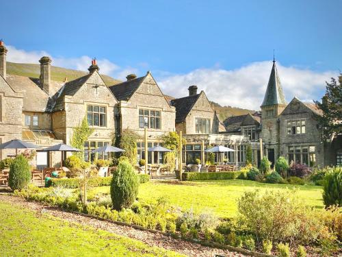 a large stone house with a lawn in front of it at Simonstone Hall Hotel in Hawes