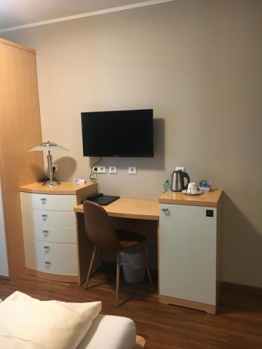 an office with a desk with a computer and a tv at Hotel-Restaurant La Fontana in Sankt Ingbert