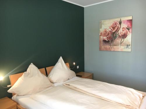 - une chambre dotée d'un lit avec des draps blancs et des roses dans l'établissement Hotel-Restaurant La Fontana Costanzo, à Saint-Ingbert