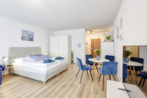 - une chambre avec un lit, des tables et des chaises dans l'établissement Relax-Apartment mit Indoor-Pool, Fitness und Netflix am Bodensee, à Uhldingen-Mühlhofen