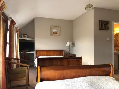 um quarto com 2 camas e uma cadeira em Harveys Guest House em Dublin