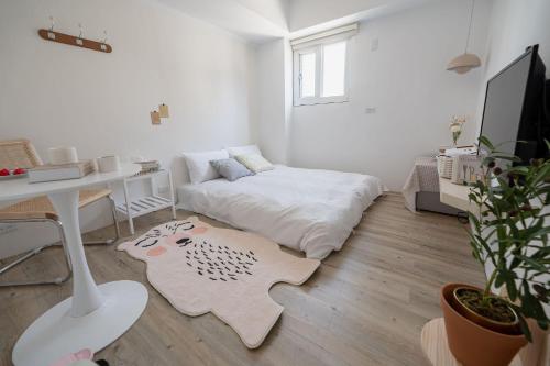 a white room with a bed and a desk at June in Tainan