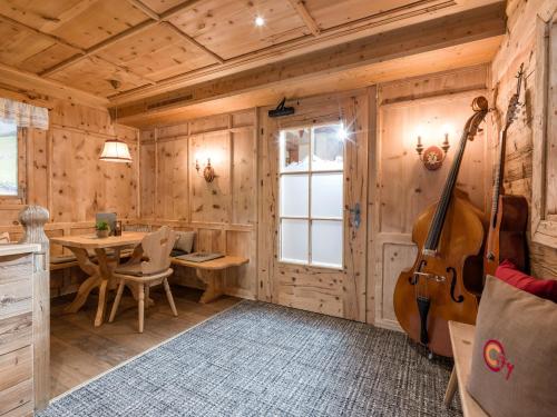 a room with a wooden wall with a guitar at Hotel Pinzger Tux in Tux