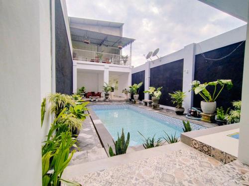 - une piscine dans une maison ornée de plantes dans l'établissement RedDoorz At Artomoro Guest House, à Yogyakarta