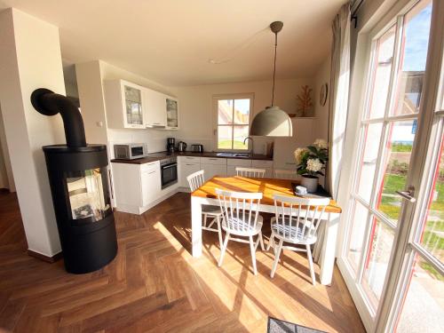 a kitchen with a table and a wood stove at Haus zwischen Mühle und Meer in Boiensdorf