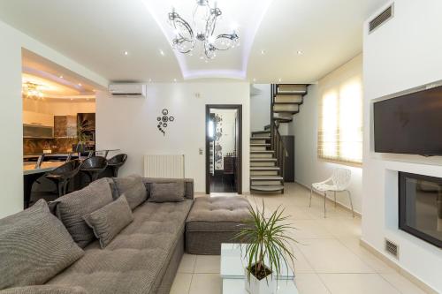 a living room with a couch and a tv at Villa Green Diamond - Private Heated Pool in Platanes