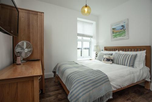 um quarto com uma cama e uma secretária com uma ventoinha em The Penthouse 15 At the Beach, Torcross em Beesands