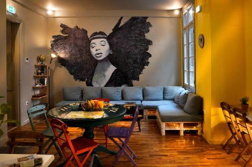 uma sala de estar com um sofá azul e uma mesa em Nubian Hostel em Atenas