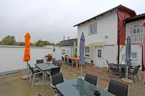 a patio with tables and chairs and umbrellas at Ferienwohnungen Greifswald_Wieck V in Wieck