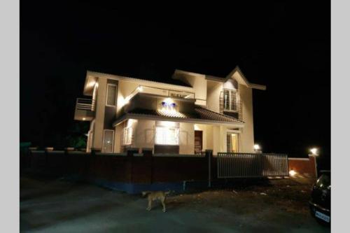 a dog standing in front of a house at night at Spandan bunglow in Alibaug