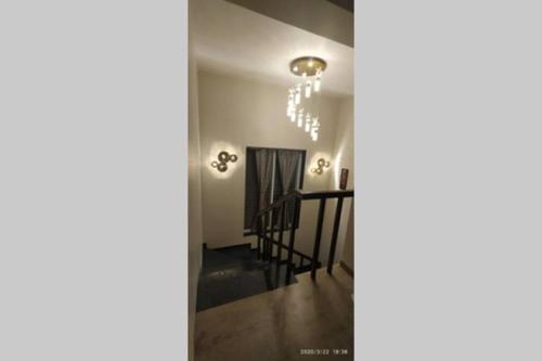 a hallway with a chandelier and a stairway at Spandan bunglow in Alibaug