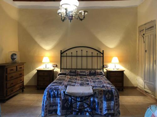 een slaapkamer met een groot bed en 2 nachtkastjes bij CORTIJO LOMA DEL BELLOTON in Cazorla