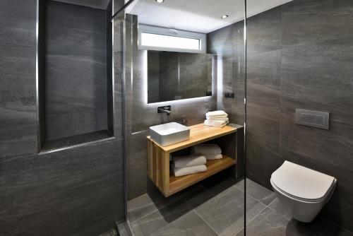 a bathroom with a toilet and a sink and a mirror at Apartmány Tri sestry Jasná in Demanovska Dolina