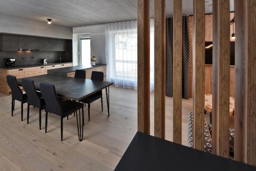 a kitchen and dining room with a table and chairs at Apartmány Tri sestry Jasná in Demanovska Dolina