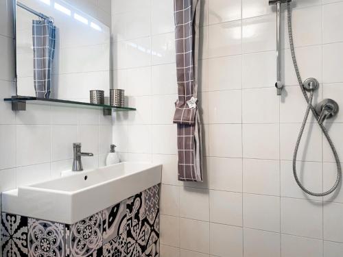 y baño blanco con lavabo y ducha. en Grazioso bilocale pieno centro, en Módena