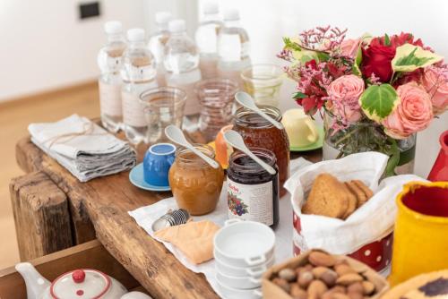 a wooden table with food and flowers and jars at Il Treno dei Sogni - Bed & Relais in Conselve