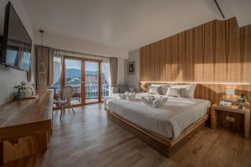 a bedroom with a large bed and a large window at Nuan Boutique Hotel in Chiang Mai