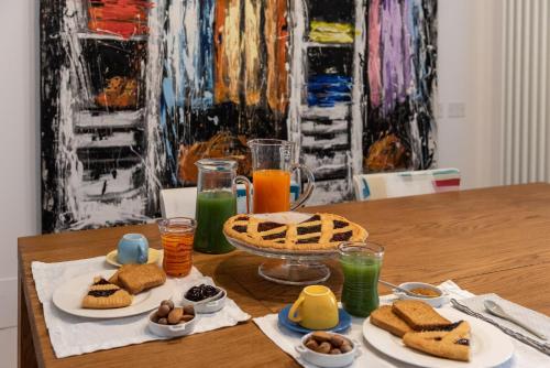 a table with sandwiches and drinks and a painting at Il Treno dei Sogni - Bed & Relais in Conselve