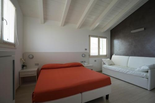 a living room with a bed and a couch at Le Terre di Maluk in Monte San Vito