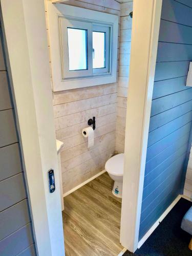 a bathroom with a toilet and a window at Jenolan Holiday Park Oberon in Oberon