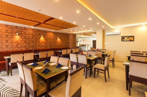 un restaurant avec des tables et des chaises et un mur en briques dans l'établissement Cygnett Style Signature, à Dharamshala