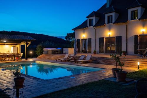 a house with a swimming pool at night at Maison de Vacances - Domaine de la Couvée in Calès