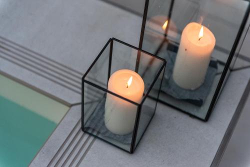 a candle in a glass holder with two mirrors at Il Treno dei Sogni - Bed & Relais in Conselve