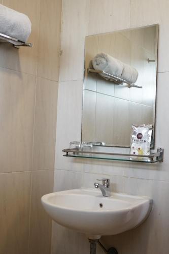 uma casa de banho com um lavatório e um espelho em Rudang Hotel & Resort Berastagi em Berastagi