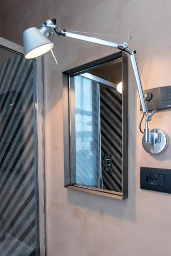 a bathroom mirror with a light on a wall at Il Treno dei Sogni - Bed & Relais in Conselve