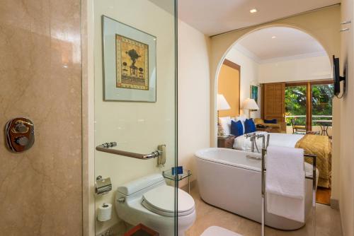 バンガロールにあるジ オベロイ バンガロールのバスルーム(バスタブ、トイレ付)、ベッドルーム1室が備わります。