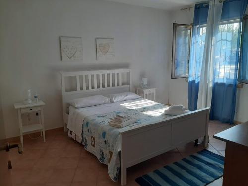 1 dormitorio con 1 cama grande y cortinas azules en Stagnone Kitesurf Paradise en Birgi Vecchi