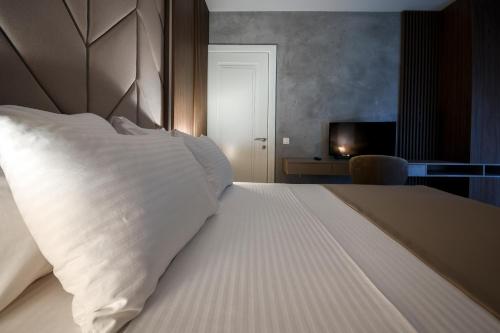 a bedroom with a bed with a white pillow at Hotel LoRa in Belgrade
