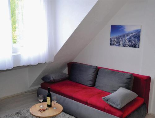 un sofá rojo en una sala de estar con mesa en Uni Kop, en Brzeće